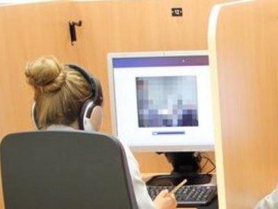 Drei Menschen sitzen jeweils vor einem Computer